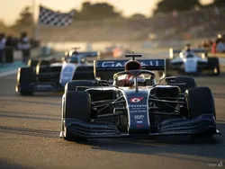 Three Formula 1 racing cars behind the checkered flag